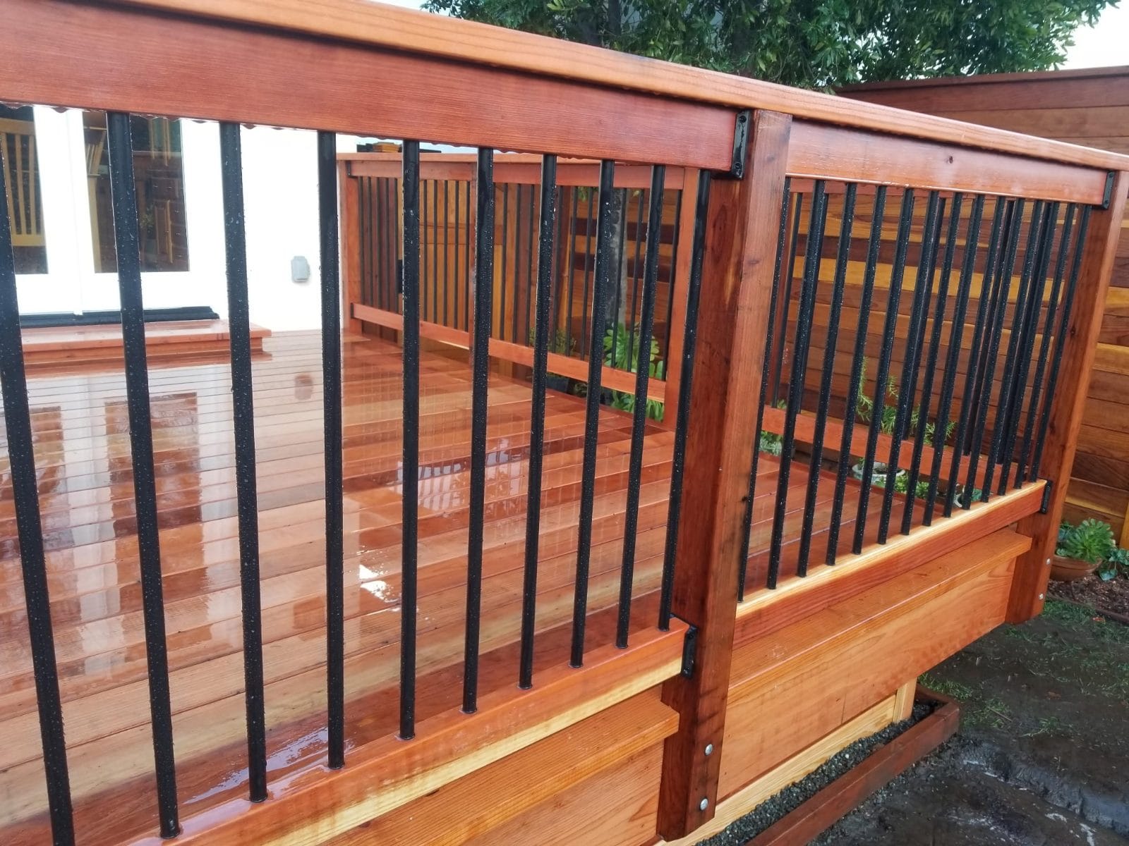 Wood deck railing with black metal balusters
