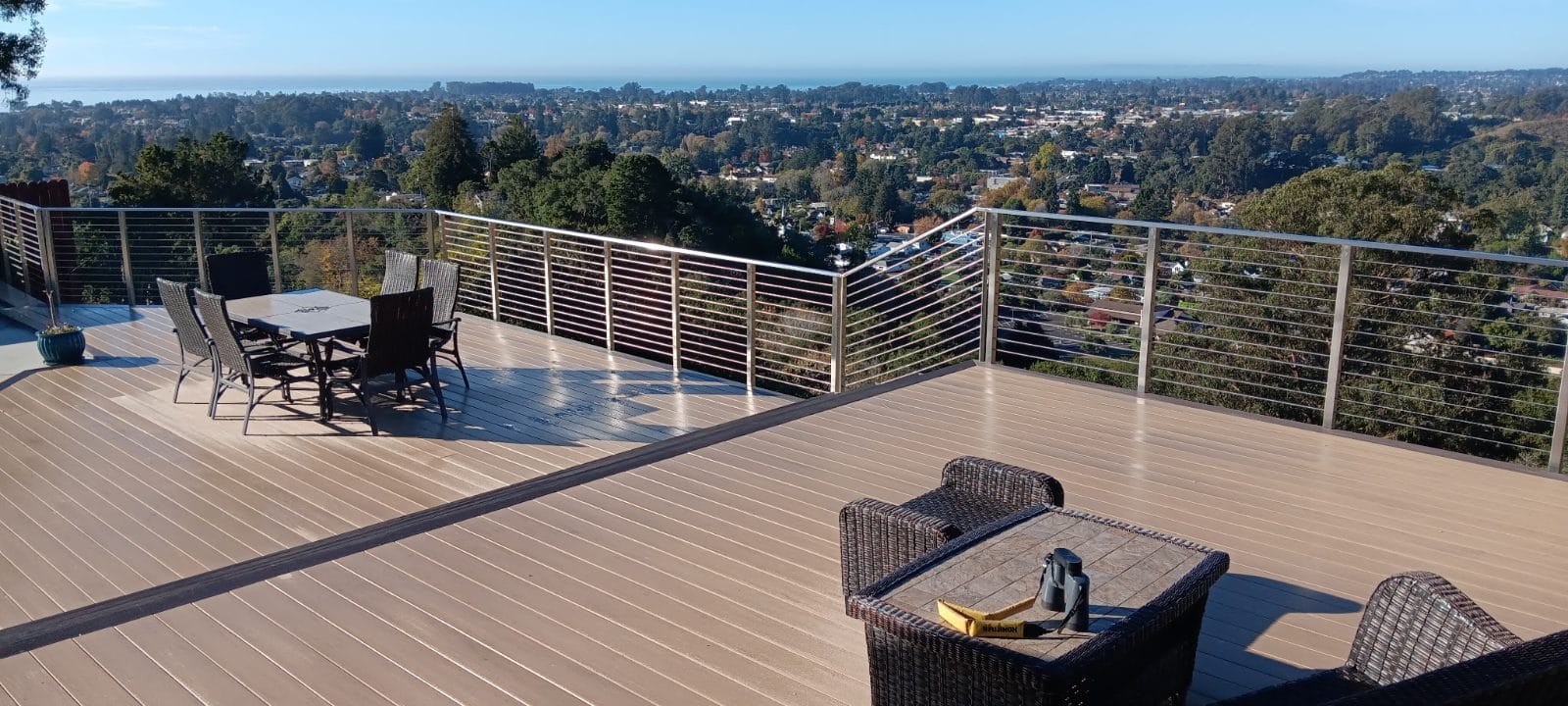 Composite deck with stainless cable railing overlooking a wide view